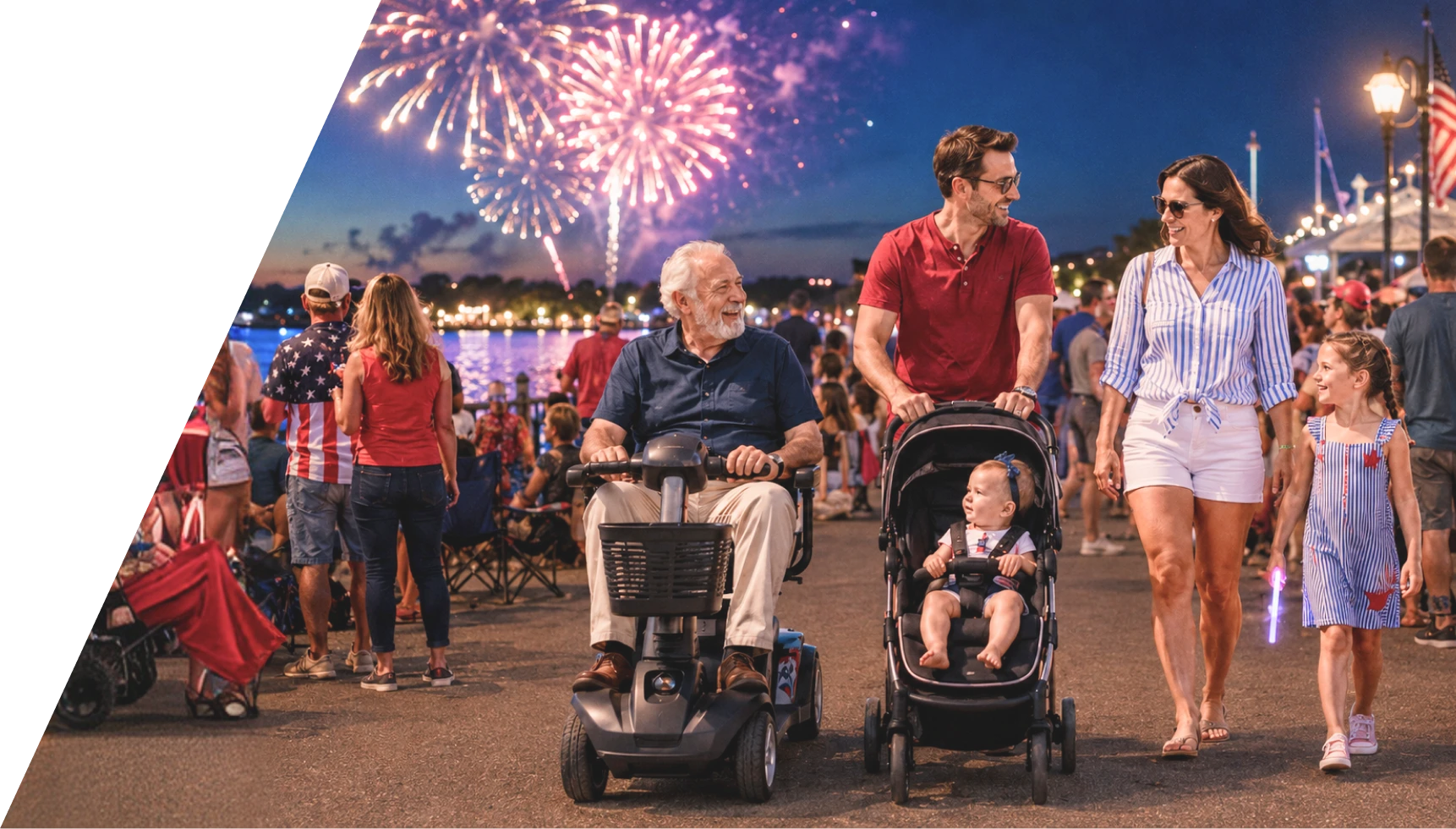 A multi-generational family walks along a crowded, lively boardwalk at night during a 4th of July celebration, with vibrant fireworks bursting in the sky over the water in the background. In the foreground, an older man with white hair smiles while riding a black mobility scooter. Next to him, a man in a red t-shirt pushes a toddler in a stroller. Beside them, a woman in a blue-and-white striped shirt and white shorts walks next to a young girl in a blue striped dress who holds a glowing purple light stick. The boardwalk is filled with other spectators, illuminated by warm string lights and street lamps, with an American flag visible on the right.